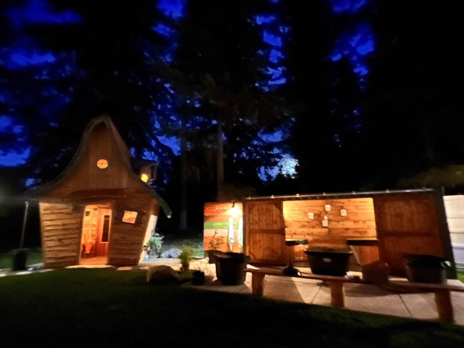 Hand-built sauna and container station lit at night